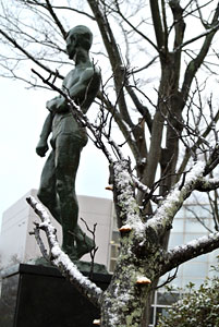 正門前の彫刻と雪化粧の梅
