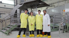 記念撮影，黄色が神戸高専の専攻科生．右がお世話になったM.Rifai氏．後ろは原子炉の炉心プールです